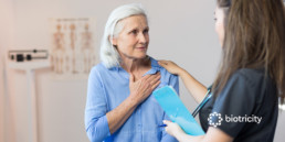 Senior woman at the doctor’s office for chest pain, requires diagnoses through a heart monitor.