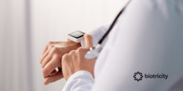 A physician is engaging with a wearable device worn on her wrist.